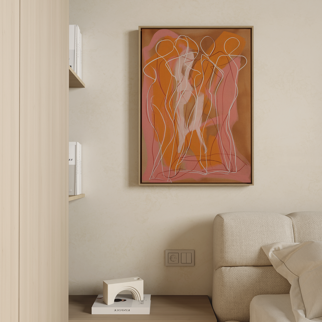 A modern living room corner features a beige sofa, a small geometric white side table with books, shelves of more books, and minimalist wall art—Dancing Silhouettes Abstract Canvas Art—hanging on the wall.