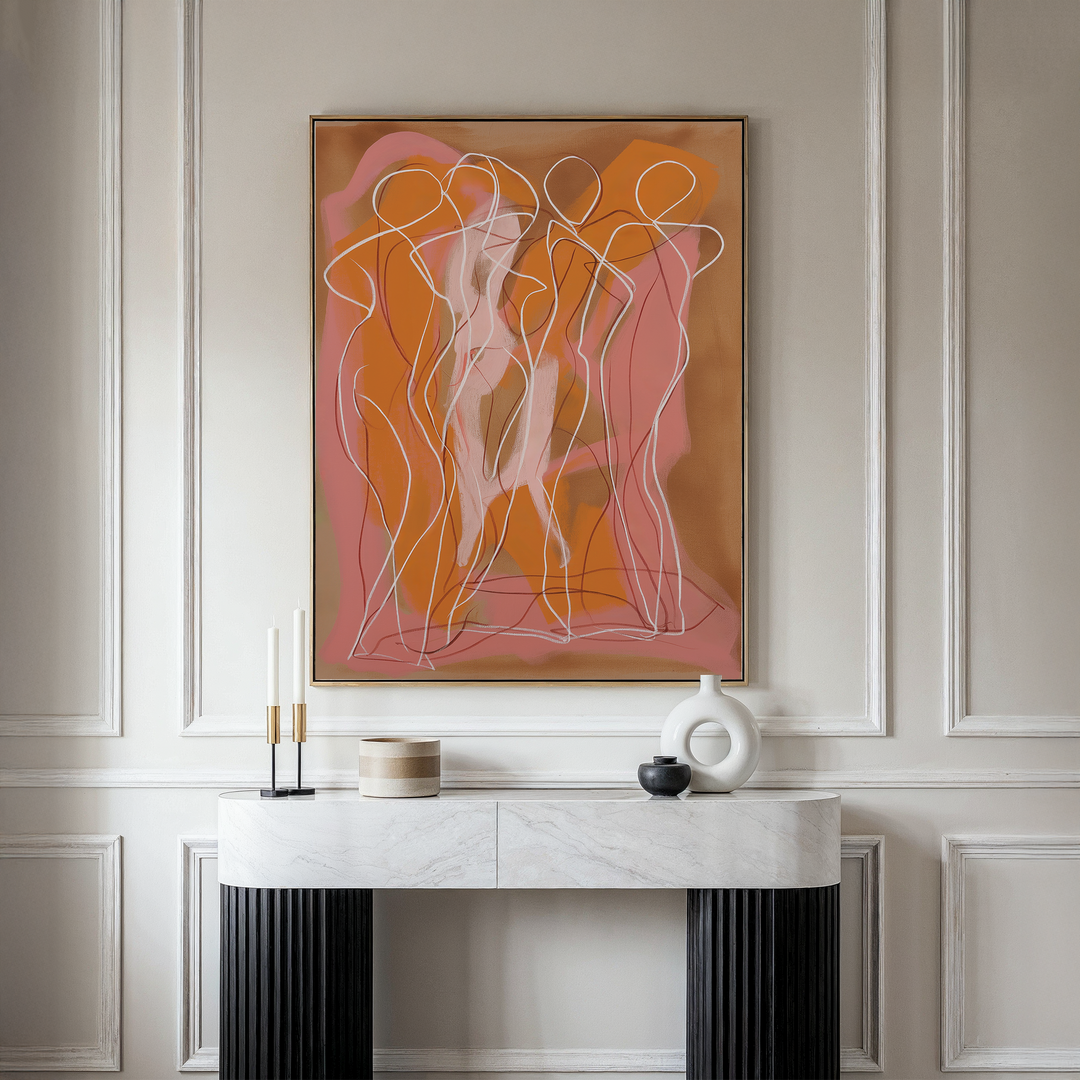 A marble console table with decorative objects stands against a beige paneled wall, topped by framed Dancing Silhouettes Abstract Canvas Art featuring minimalist, overlapping human figures in orange, pink, and white.