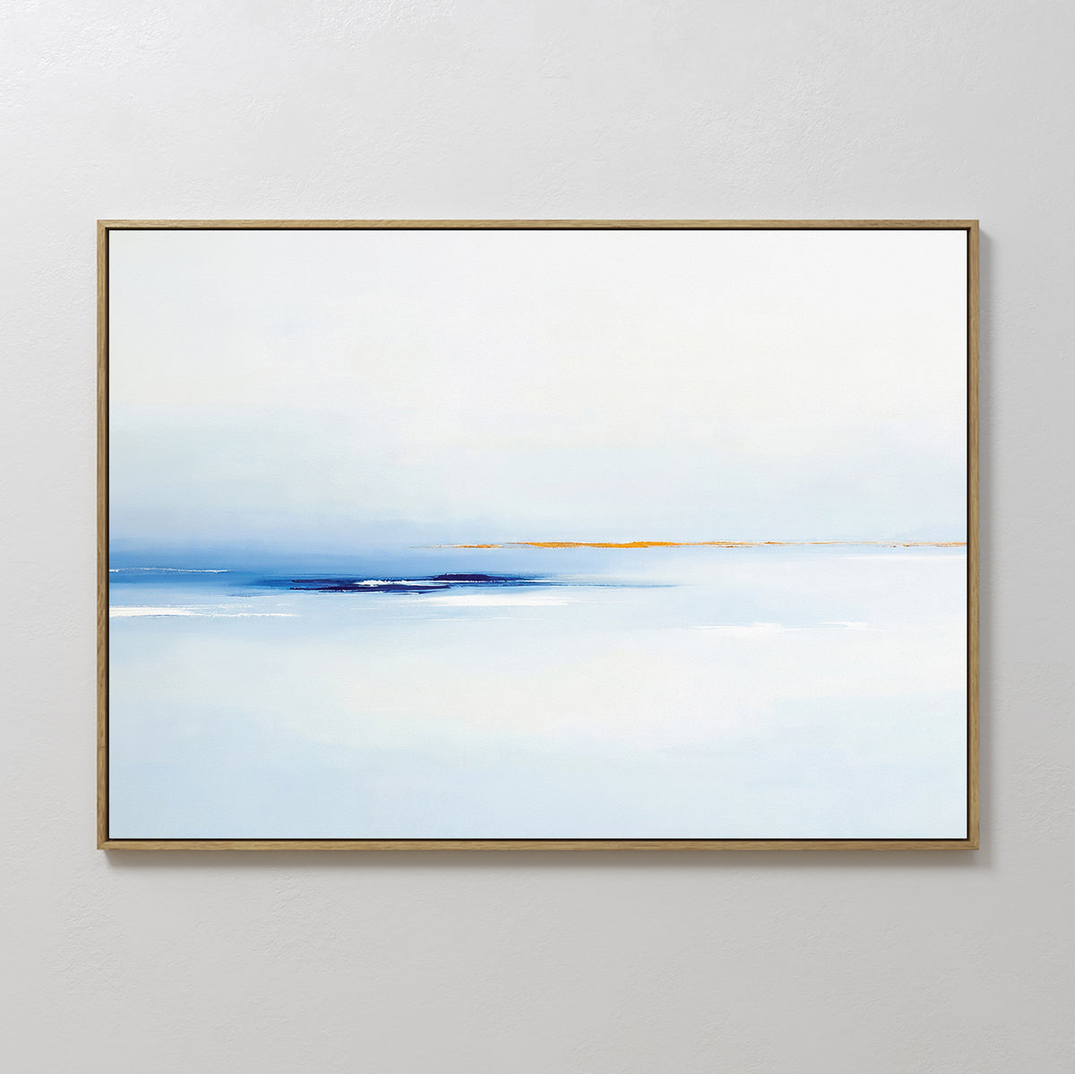 The Distant Archipelago Canvas Art - Horizontal features soft blue and white tones, a hazy horizon with warm yellow accents near the center, and is framed in thin gold, displayed on a plain white wall.