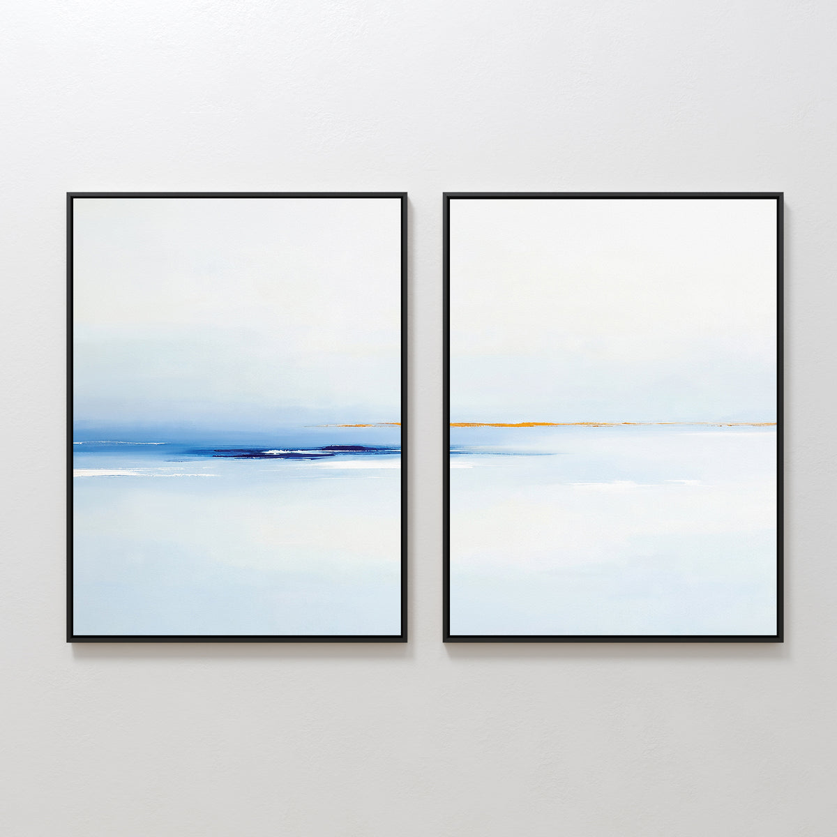Distant Archipelago - Set Of 2 features minimalist abstract paintings in black frames with soft blue, white, and subtle orange tones, evoking a calm landscape—ideal contemporary wall art for a serene space.