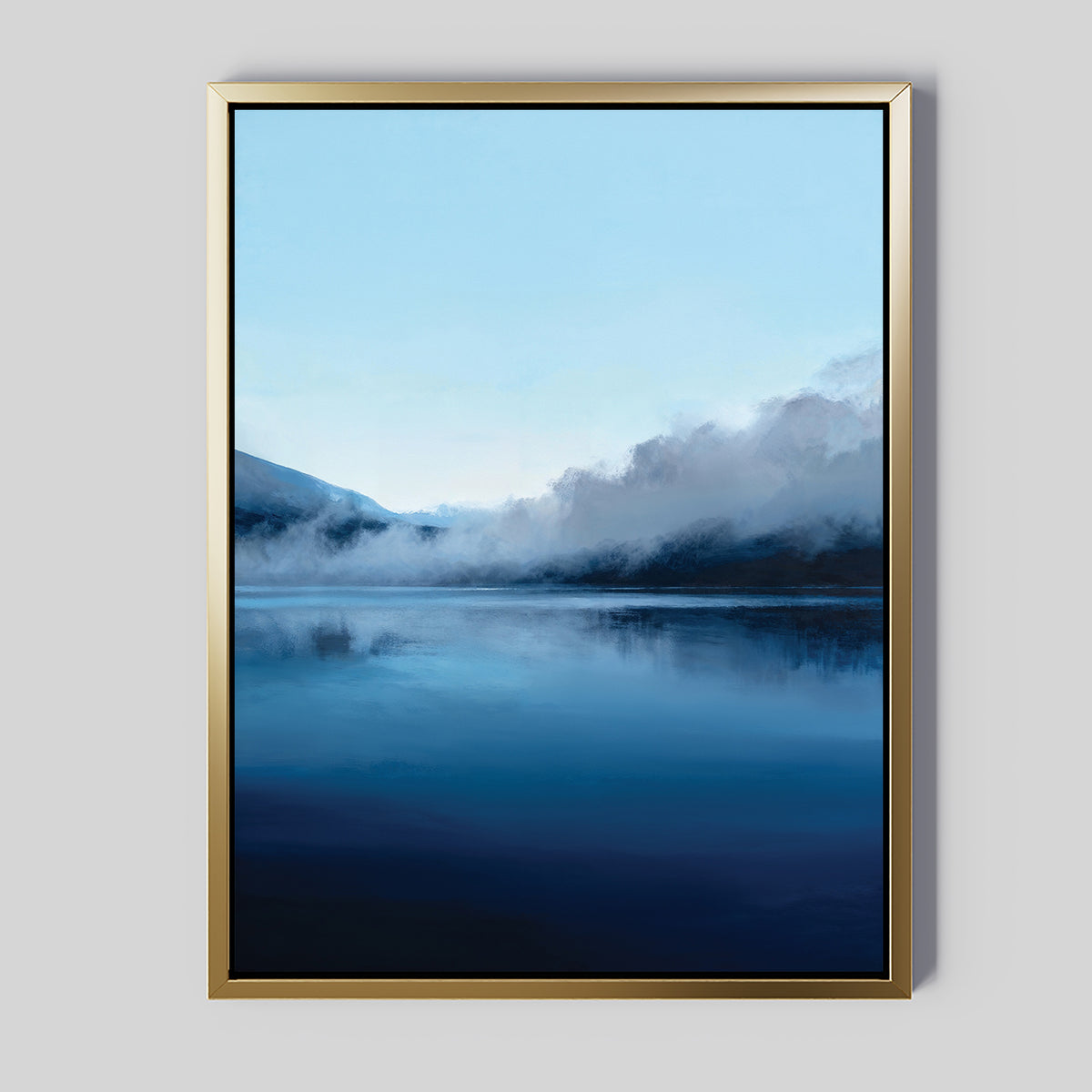 The Fjord Mist Canvas Art - Vertical features a serene lake with calm blue water, distant mountains, and drifting mist—ideal Nordic decor to complement any light gray wall.