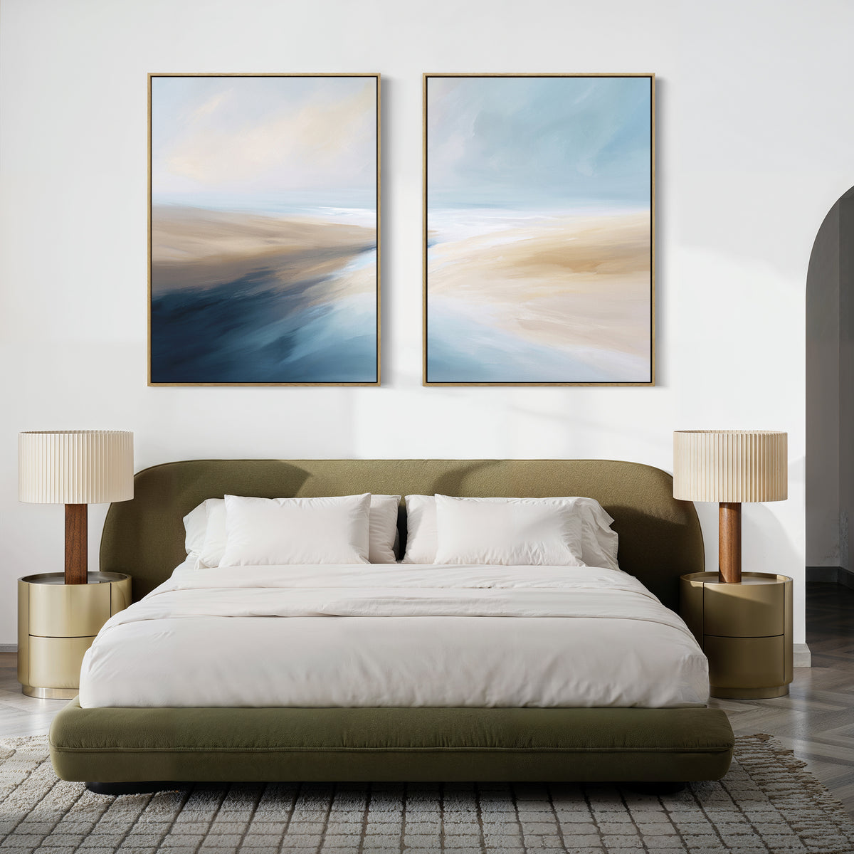 A modern bedroom with a green upholstered bed, white bedding, gold nightstands, pleated lamps, and Fluid Motion - Set Of 2 abstract blue and beige paintings above the bed adds a chic touch to the decor.