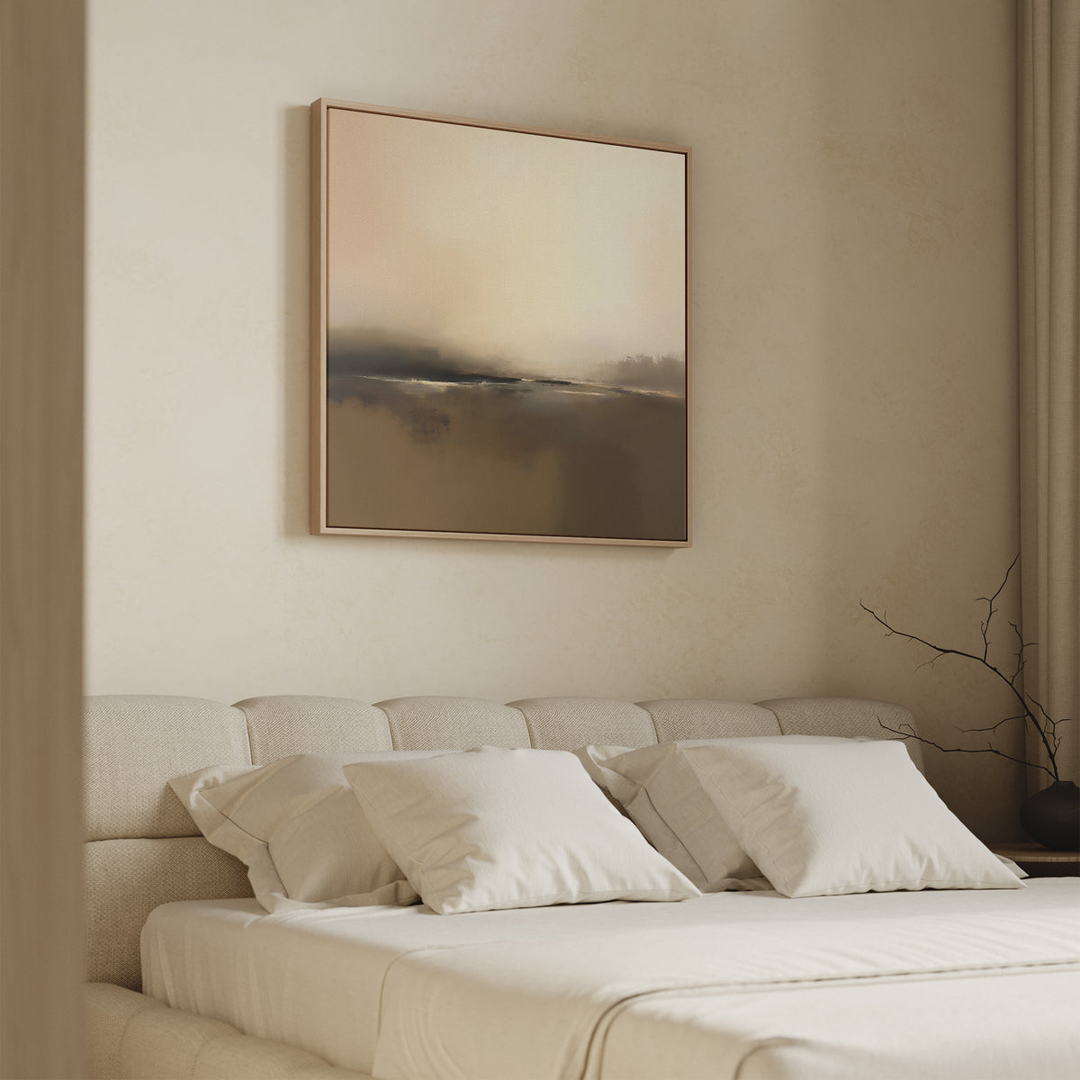 A minimalist bedroom features a beige upholstered bed with white bedding and pillows. Above, the "Foggy Beach Expanse Canvas Art - Square" in soft neutrals adds serenity. A vase with a branch on the bedside table completes the Nordic decor style.