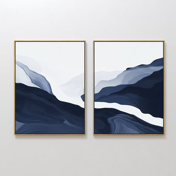 The Glacier Flow - Set Of 2 features framed abstract wall art with flowing navy blue, gray, and white shapes reminiscent of mountains or waves—an ideal accent for modern Nordic interiors.