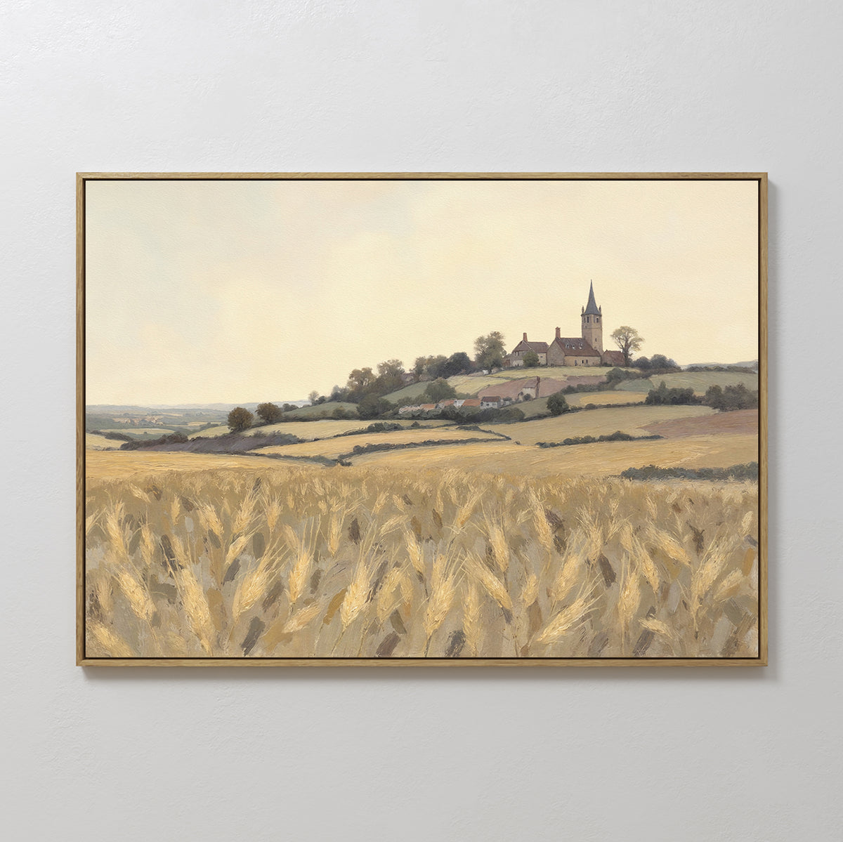 The "Harvest Chapel Canvas Art - Horizontal" is a framed rustic wall art depicting a golden wheat field, rolling hills, and a hilltop church with houses under a pale sky—ideal for pastoral home decor.