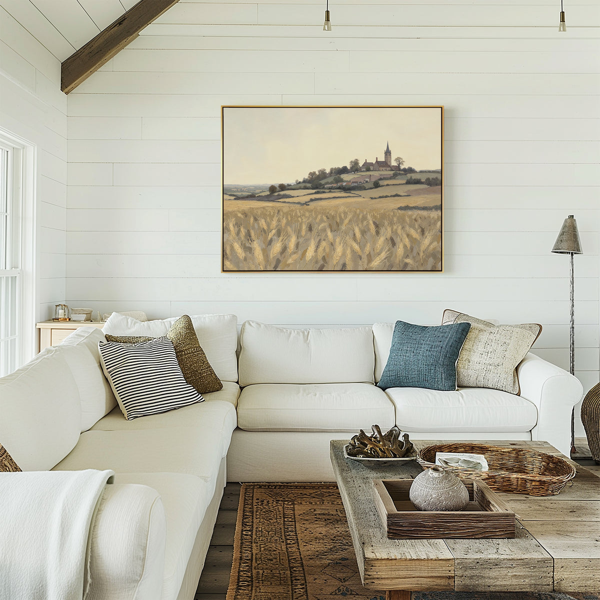A bright living room with white shiplap walls, a large white sectional, a rustic wood coffee table, and the Harvest Chapel Canvas Art - Horizontal hanging above the couch.