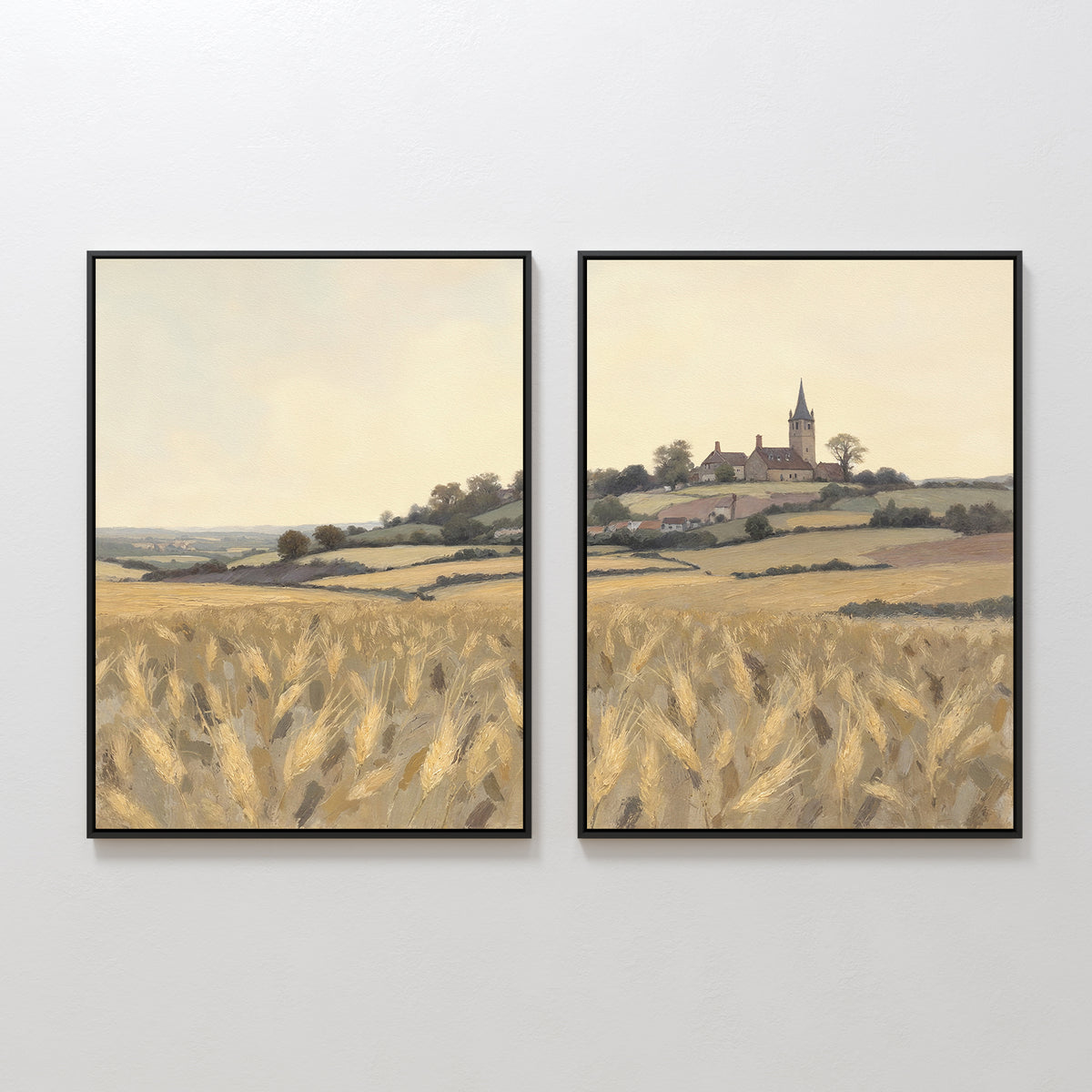 The Harvest Chapel - Set of 2 features framed canvas prints showing a golden wheat field, rolling hills, and a distant village with a church steeple, all beneath a pale sky that flows seamlessly across both prints.