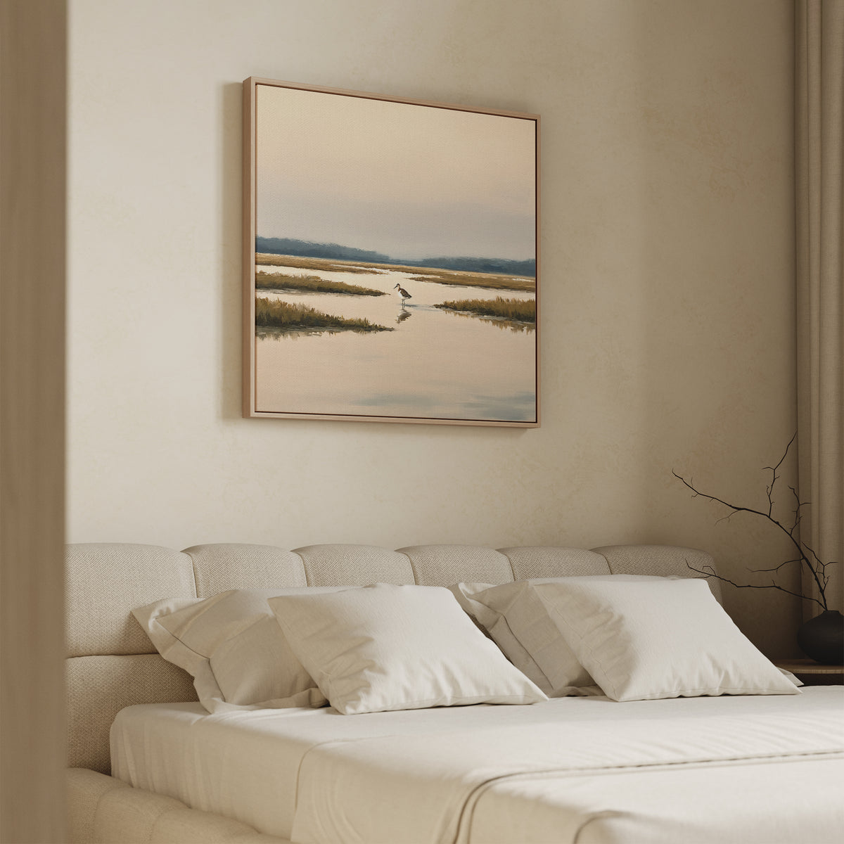 A beige bedroom features a neatly made bed with cream pillows and the Marsh Bird Canvas Art - Square above the headboard. A bare branch on the bedside table complements the room’s soft, neutral tones.