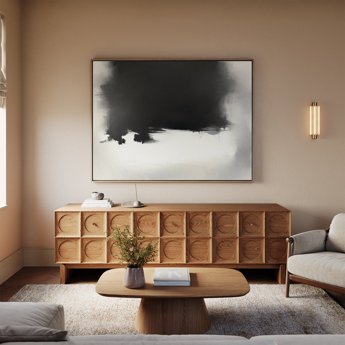 A modern living room with a wooden coffee table and sideboard, beige walls, a light sofa, the Ink Cloud Formation Canvas Art - Horizontal as a statement piece, a wall sconce, and fresh flowers in a vase on the table.