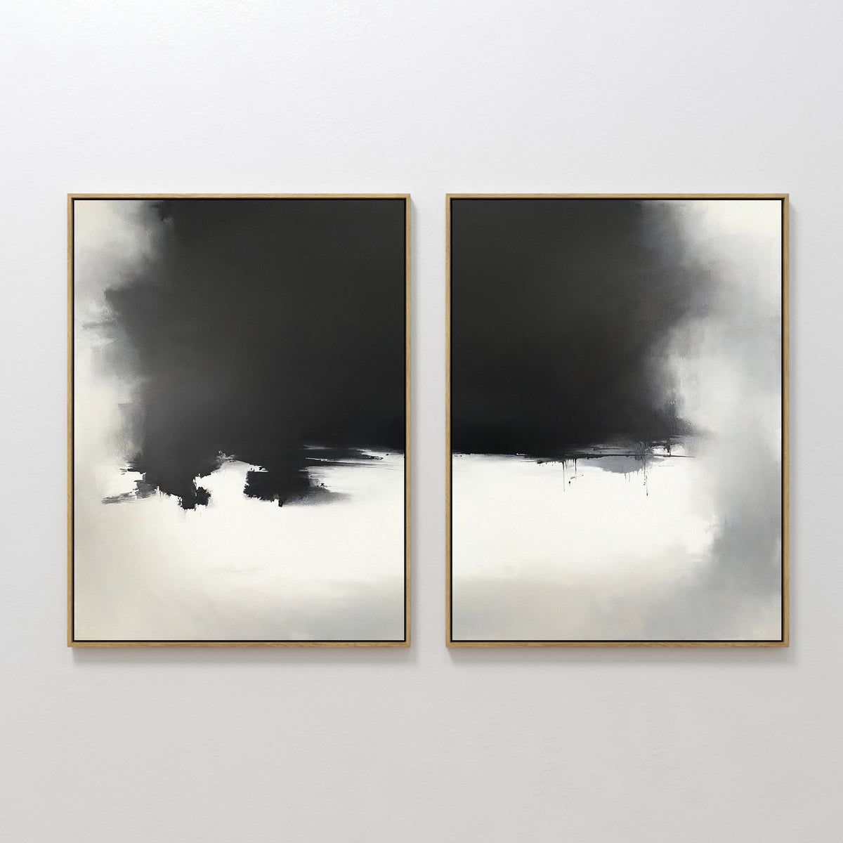 The Ink Cloud Formation - Set Of 2 features two modern, abstract black and white paintings in gold frames. Bold ink areas blend into soft smoky gradients and subtle edges, adding drama to any wall décor.