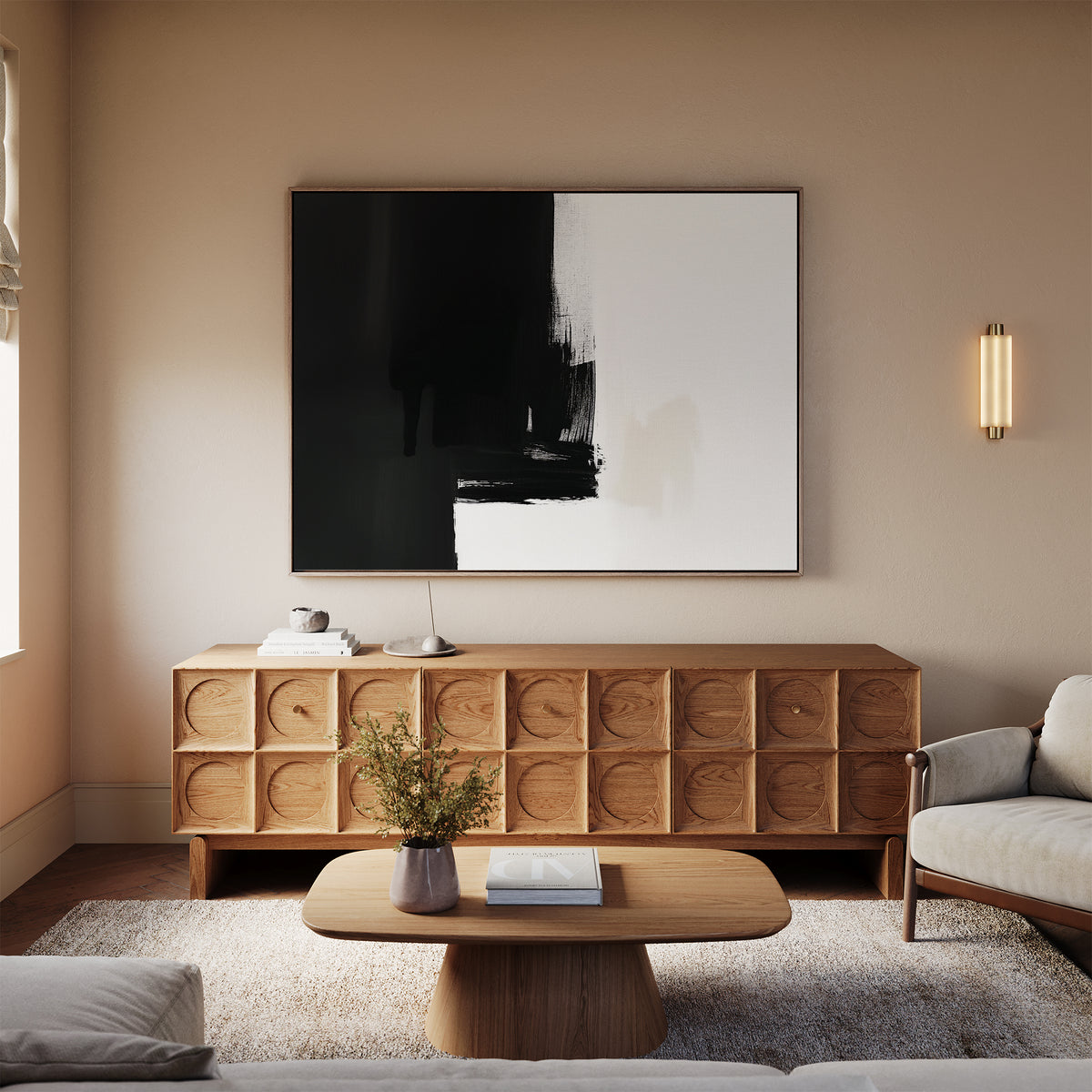 A modern living room with neutral tones exudes elegance, featuring a light wood coffee table, matching sideboard with geometric patterns, beige sofa, textured rug, and the Ink Divide Canvas Art - Horizontal as striking wall decor.