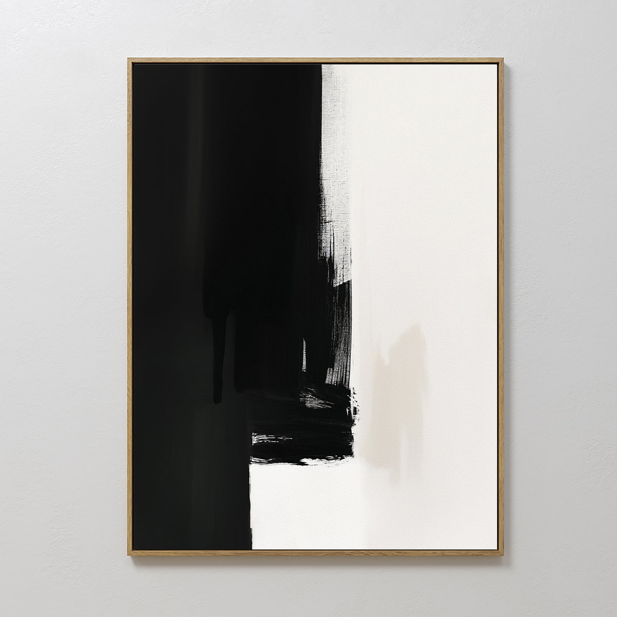 The Ink Divide Canvas Art - Vertical features bold black brushstrokes blending into white with textured, uneven edges, epitomizing minimalist wall art. Hung on a plain white wall, its striking abstract design makes a modern statement.