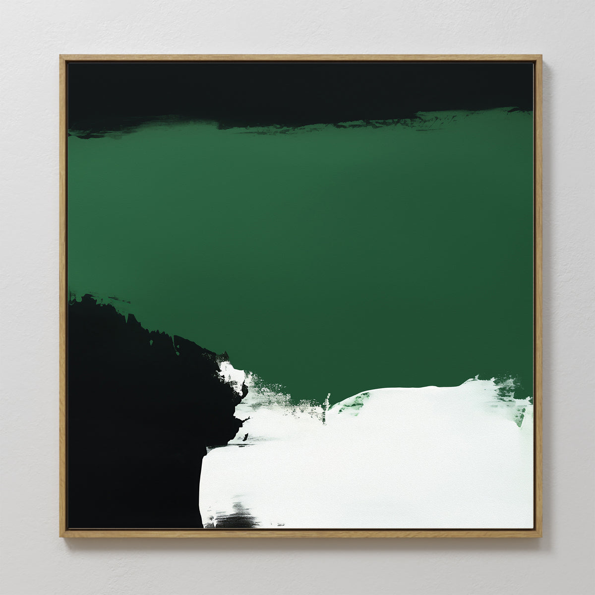 The Jade Depths Canvas Art - Square features an abstract design with a prominent emerald green section, black lower left area, and a bold white brushstroke. This contemporary piece is framed in light wood and shown against a pale wall.