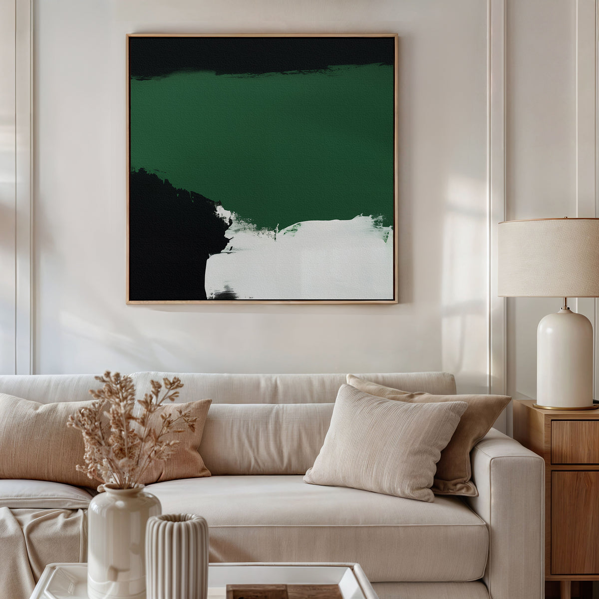 A modern living room features a beige sofa, cream pillows, a round beige lamp on a wooden side table, dried flowers in a vase, and the striking Jade Depths Canvas Art - Square as emerald green wall art for contemporary flair.