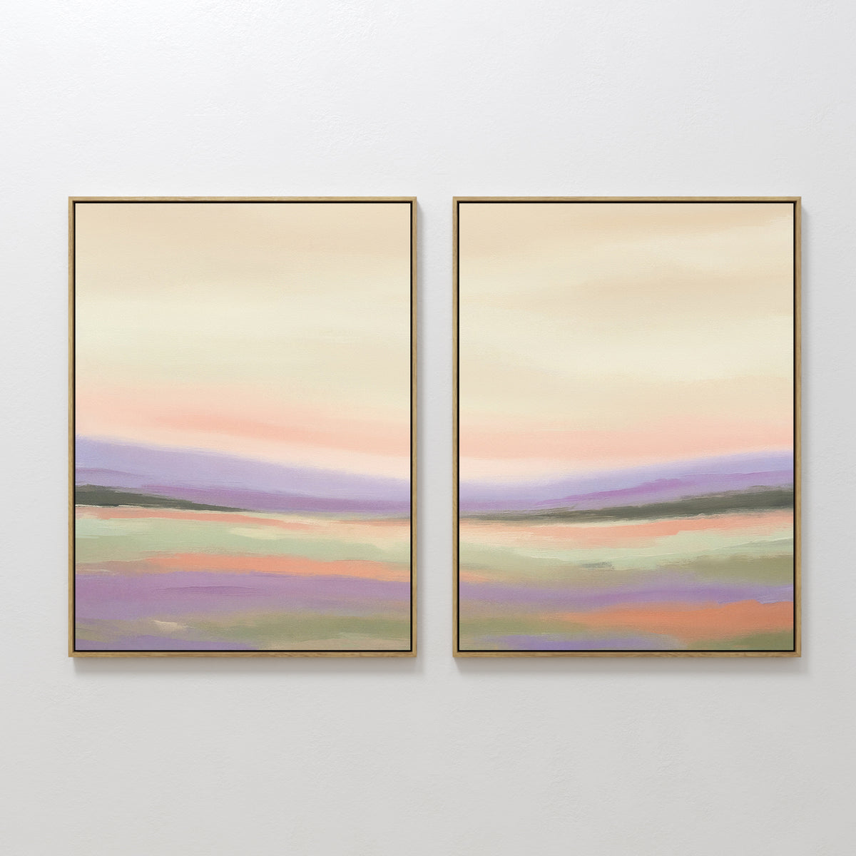 Lavender Valley - Set Of 2 features framed abstract landscape paintings in soft pastel hues of pink, lavender, green, and cream. Displayed side by side, these serene artworks depict a tranquil horizon and gentle sky on a white wall.