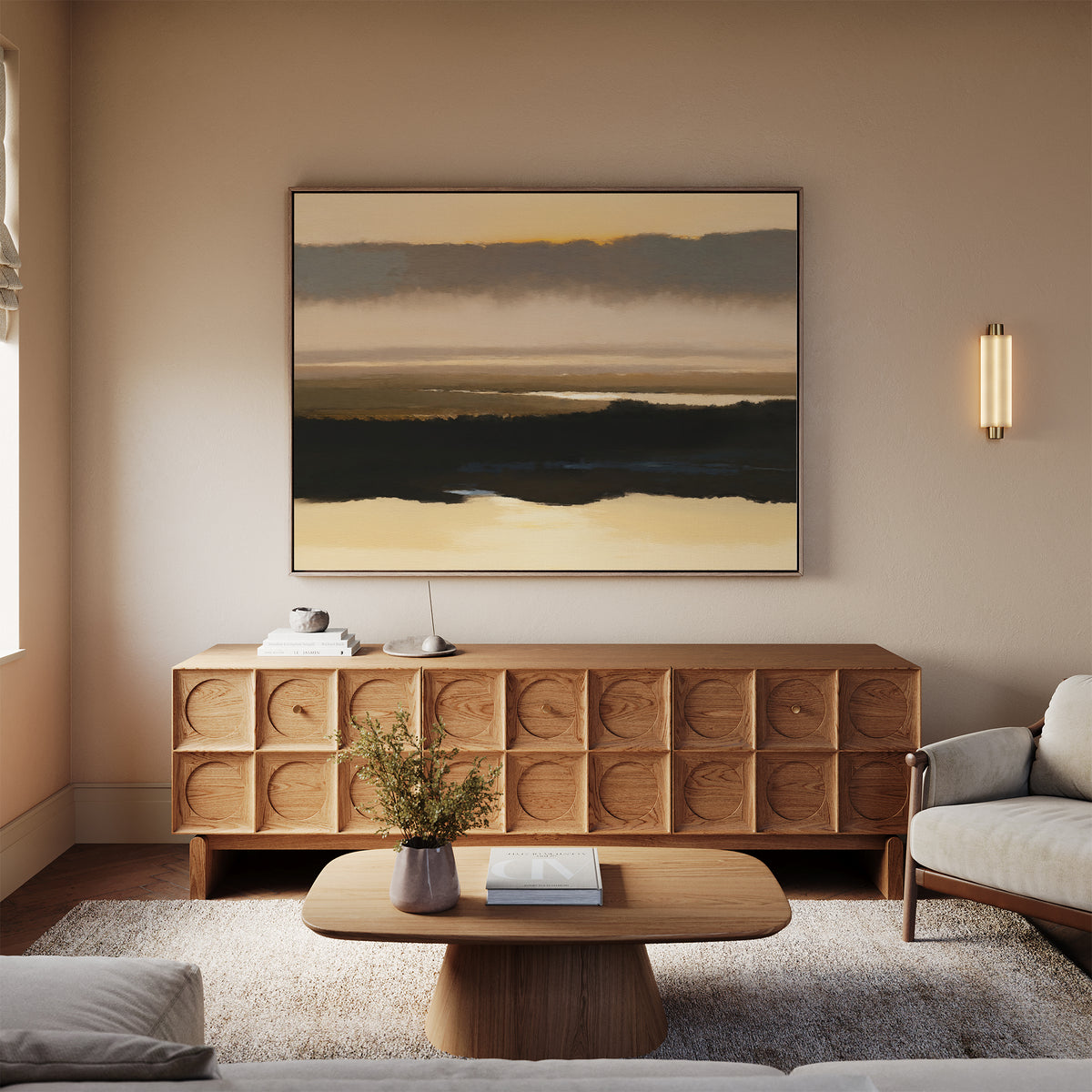 A modern living room with a light beige sofa, wooden coffee table, textured sideboard, serene decor, the Layered Valley Dawn Canvas Art - Horizontal above, a small plant, books, and soft natural lighting.