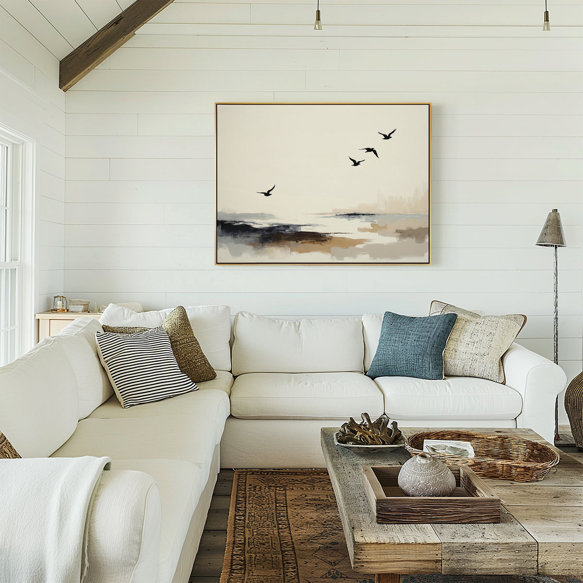 A cozy living room features a white sectional sofa, neutral pillows, a rustic wooden coffee table, and the Maritime Flight Canvas Art - Horizontal depicting birds in flight, all set against crisp white shiplap walls.