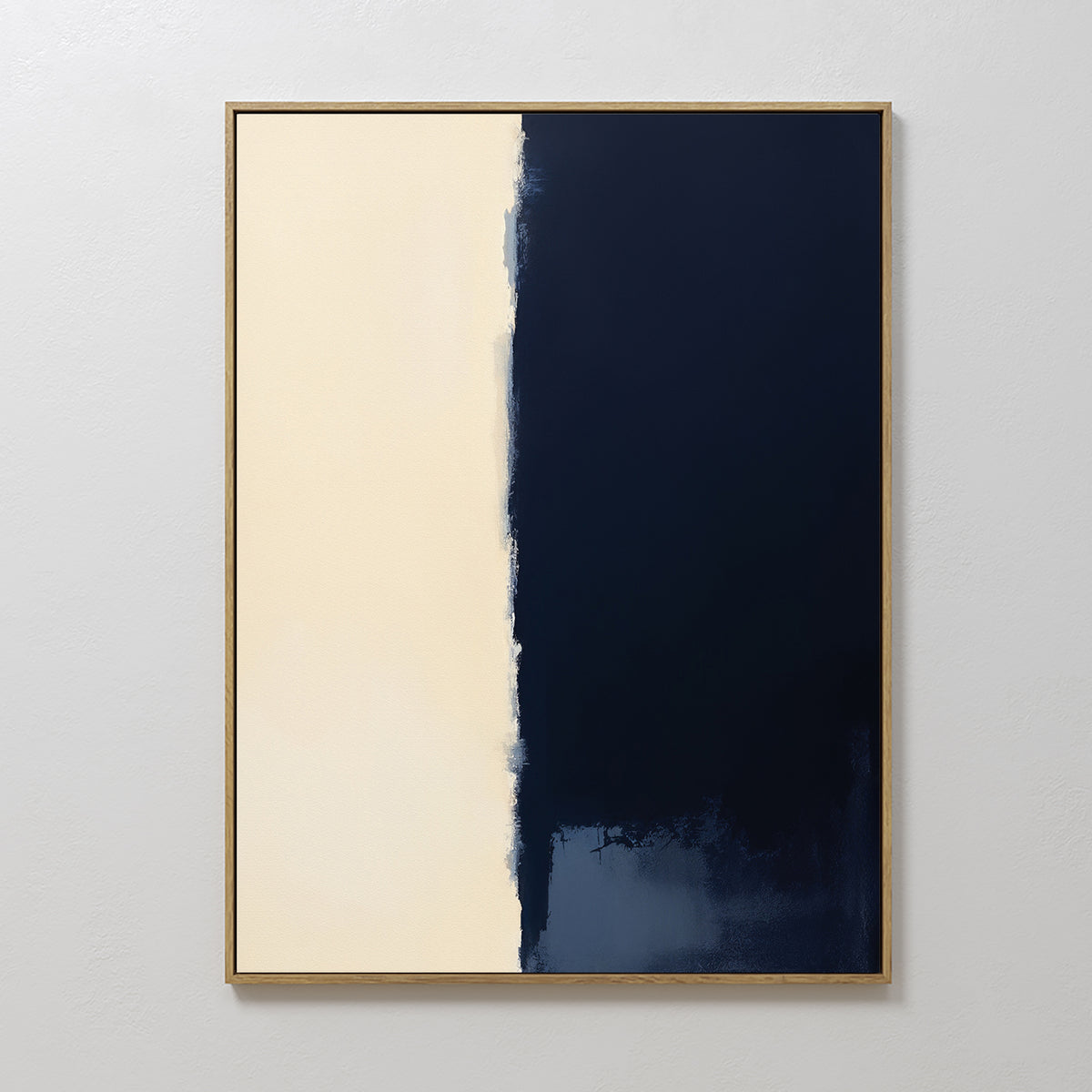 The Navy Division Canvas Art - Vertical features two halves: a textured creamy beige on the left and deep navy blue on the right with an uneven border. A simple, light frame adds modern elegance to this minimalist artwork.