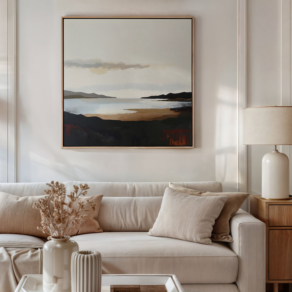 A modern living room features a beige sofa with neutral pillows, a vase of dried flowers on the table, and the Nordic Waters Canvas Art - Square hanging above the sofa for a serene touch. A lamp rests on a wooden side table.