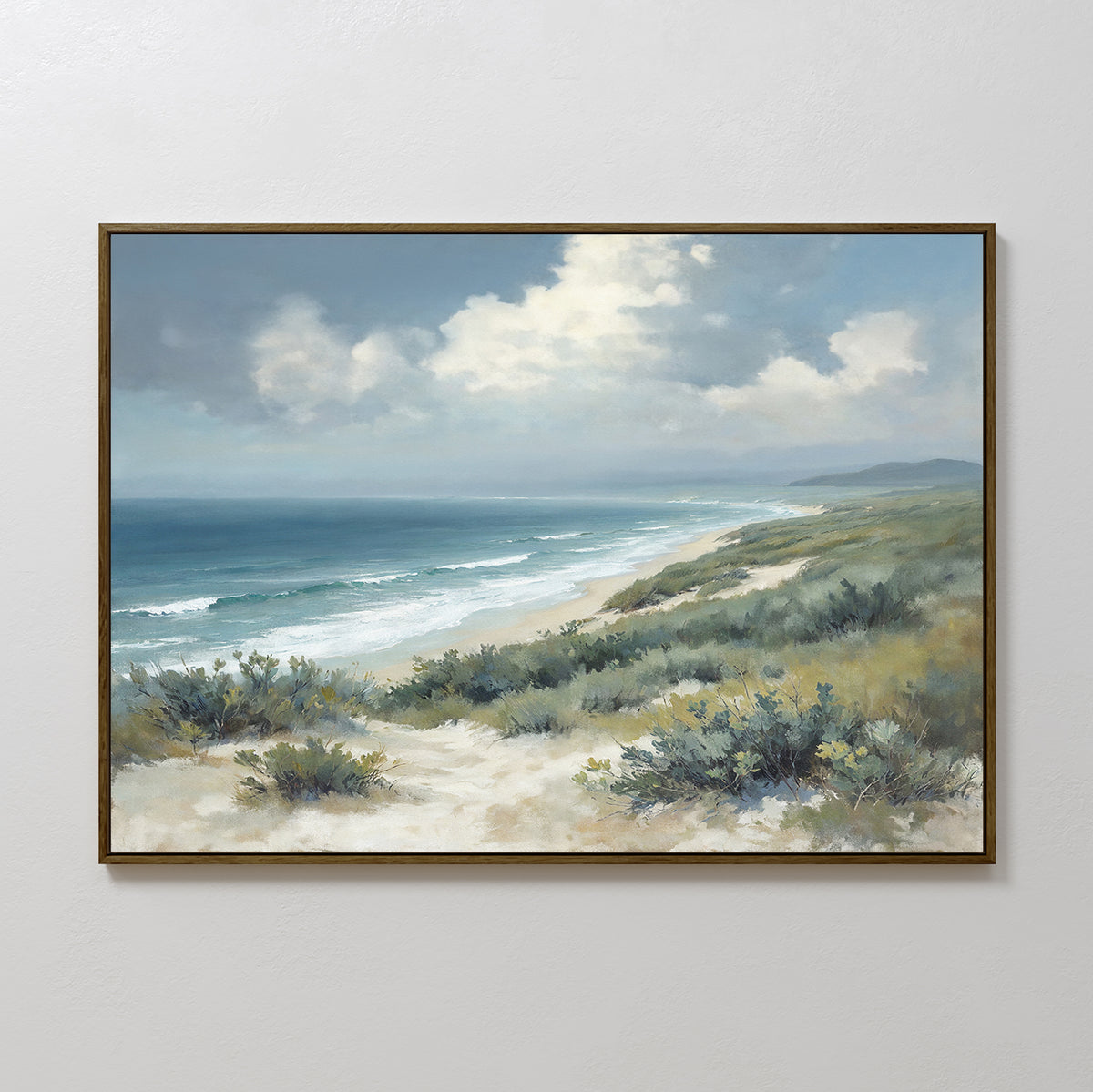 The Ocean Bluff Canvas Art - Horizontal features a framed print of sand dunes with greenery, waves meeting the shore, and a cloudy blue sky. The coastal scene stretches into the distance, capturing a tranquil beach landscape.