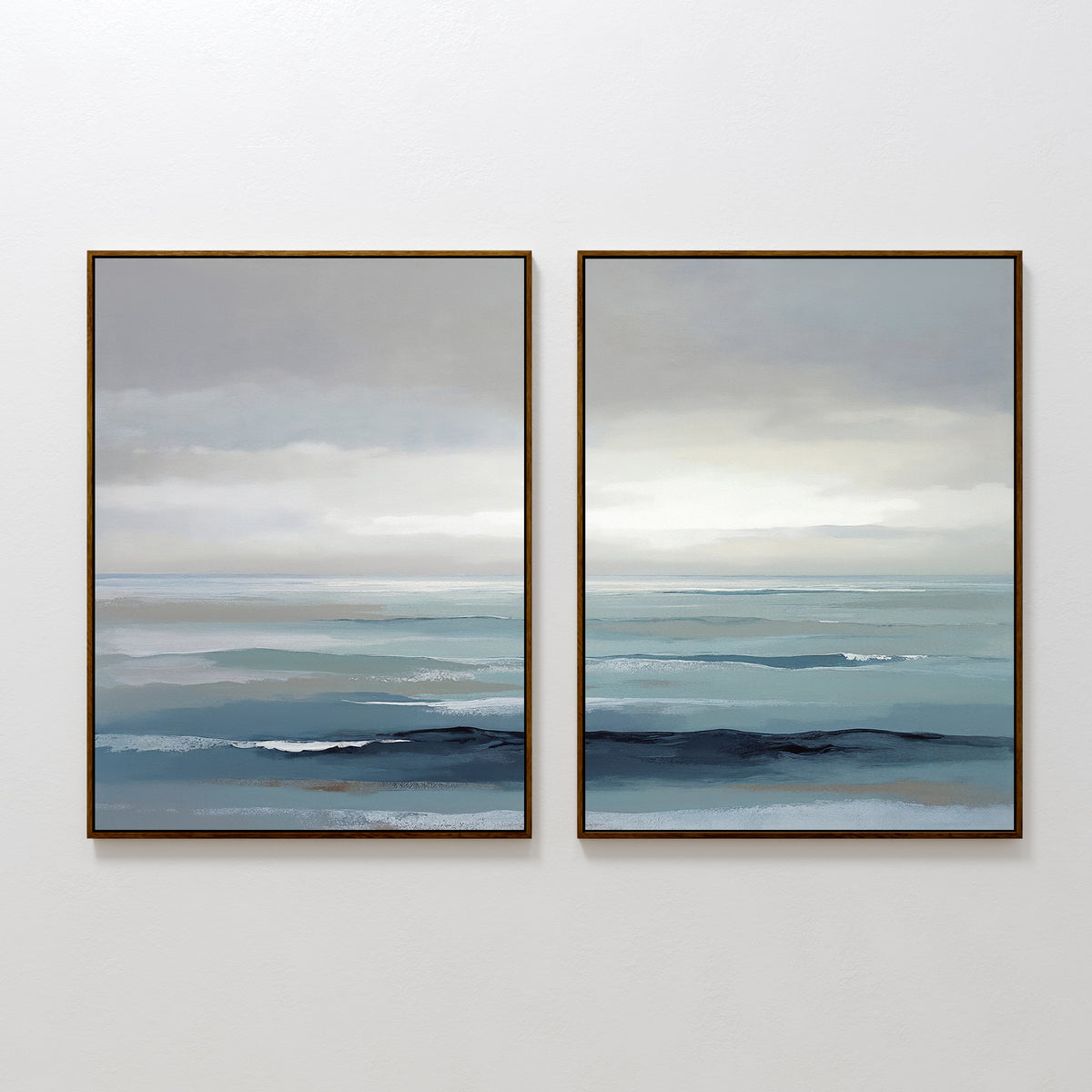 Ocean Swells - Set Of 2 features two framed paintings of a calm seascape in blue, gray, and white tones, with gentle waves under a cloudy sky. This serene, minimalist wall art brings a peaceful touch to any space.