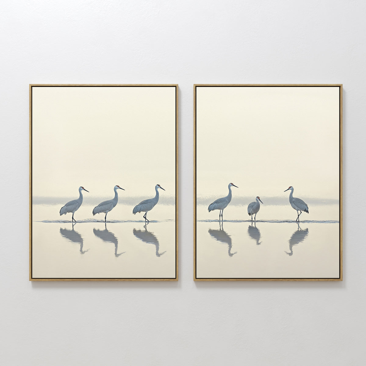 The Sandhill Procession - Set Of 2 features minimalist wall art prints of herons in soft neutral tones. Displayed side by side, these calming artworks bring serene decor to any white wall.