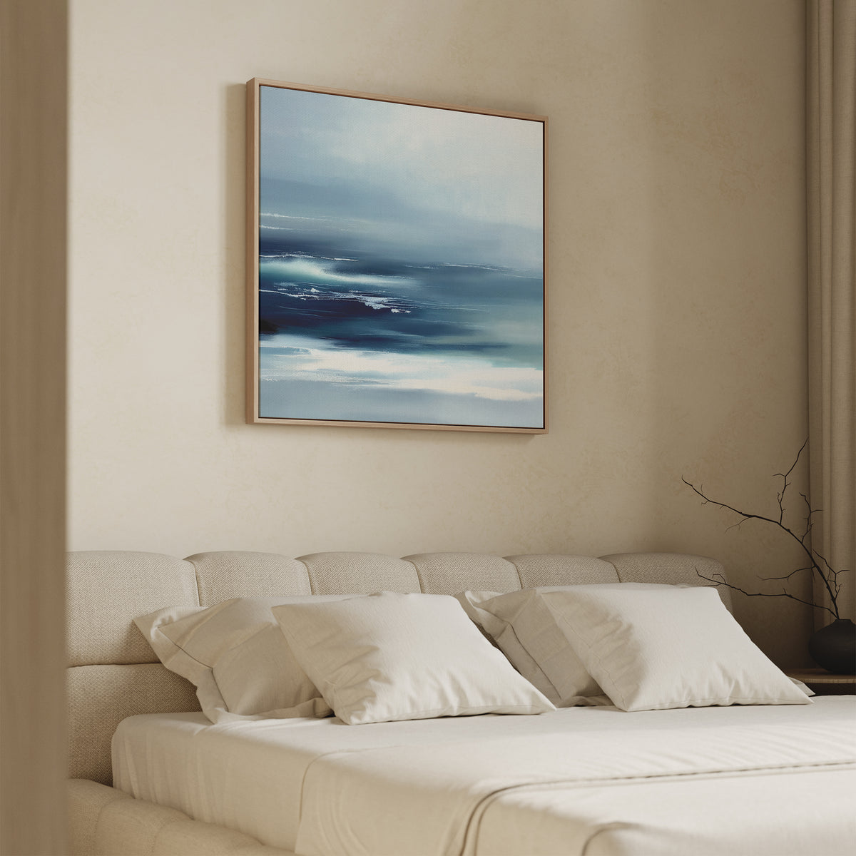 A minimalist bedroom with a beige upholstered bed and white bedding, featuring the Sapphire Current Canvas Art - Square above the headboard, plus a bare branch in a vase on the nightstand.
