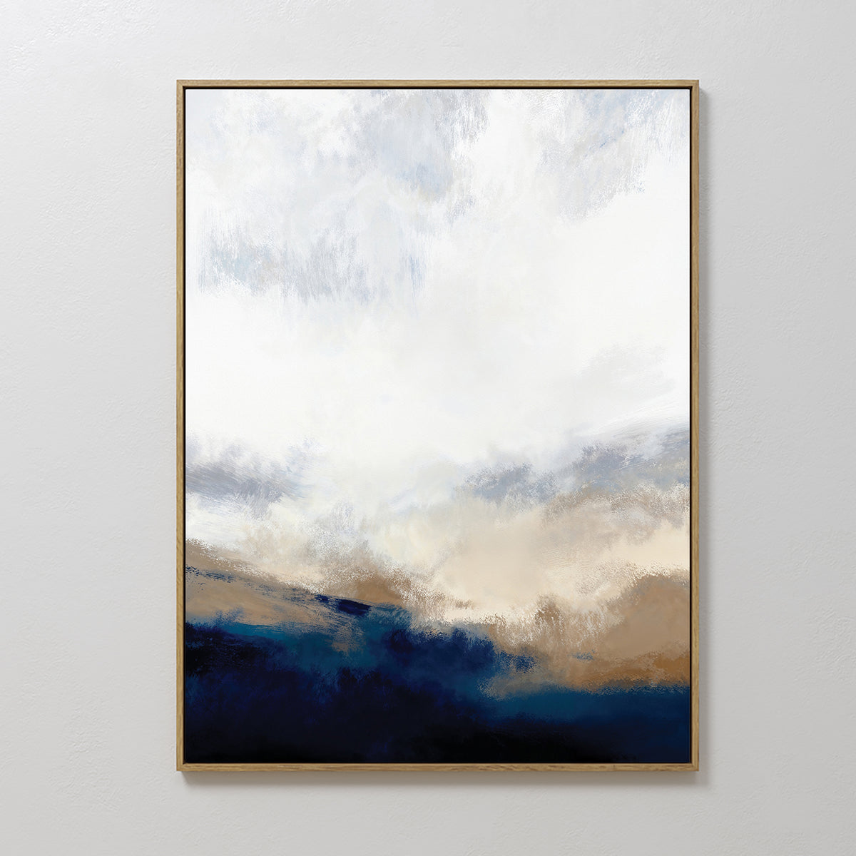 The Sapphire Tides Canvas Art - Vertical features a gold frame and soft blends of white, beige, and cobalt blue, evoking a cloudy sky above a dark landscape—ideal for modern living rooms with a minimal aesthetic.