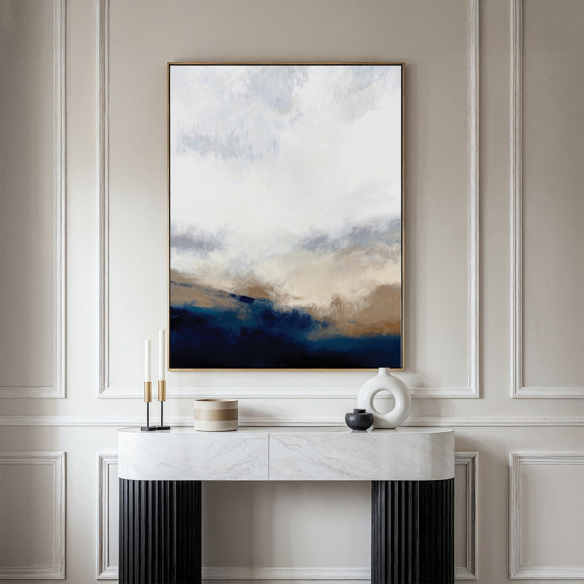 A modern entryway features a white marble console table, decorative accents, and the Sapphire Tides Canvas Art - Vertical in neutral and cobalt blues on a beige paneled wall—perfect living room inspiration.