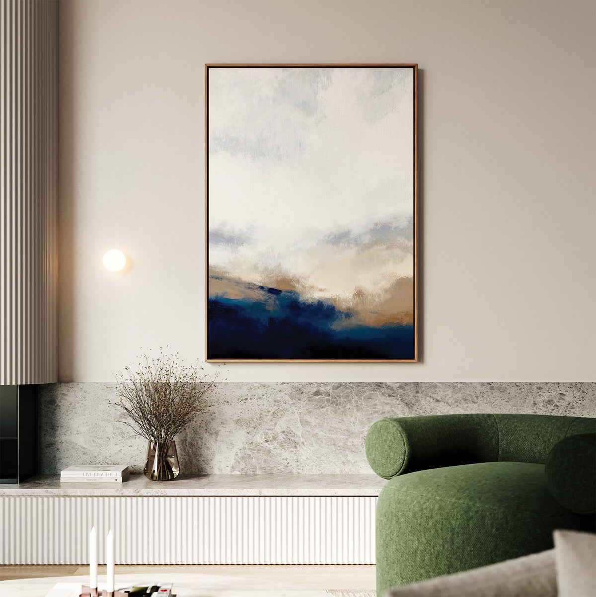 A modern living room features the Sapphire Tides Canvas Art - Vertical in cobalt blues, beige, and white on the wall, paired with a round green sofa, marble bench, dried branch vase, and minimal wall light.