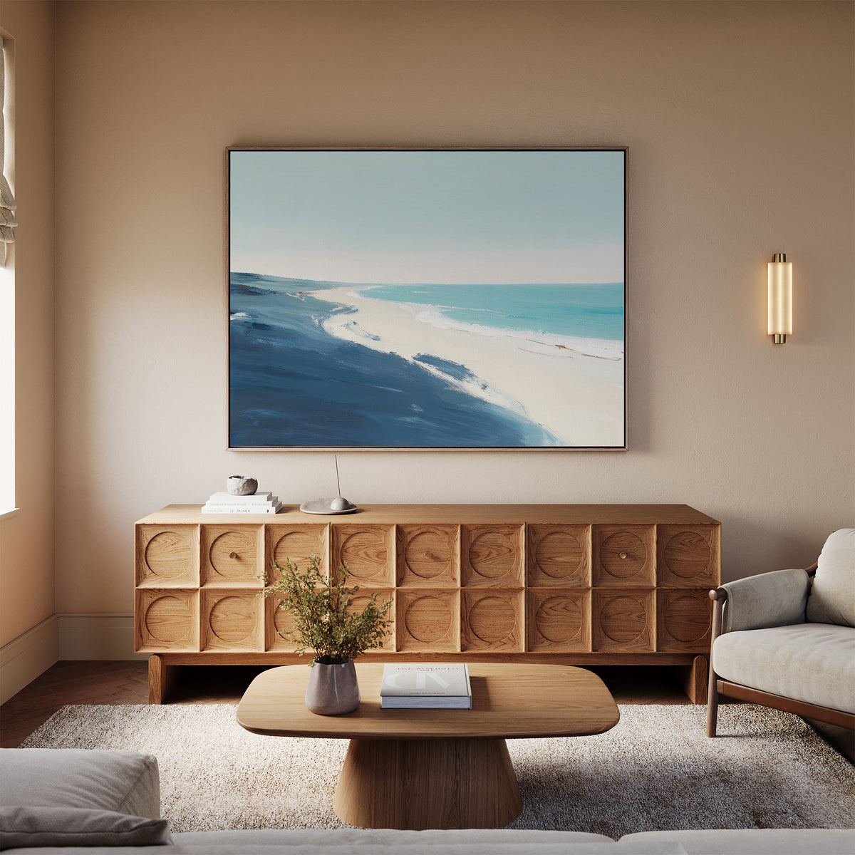 A cozy living room with neutral walls, a light sofa, wooden coffee table and sideboard is decorated with the Shifting Tides Canvas Art - Horizontal above the sideboard and a vase of flowers on the table.
