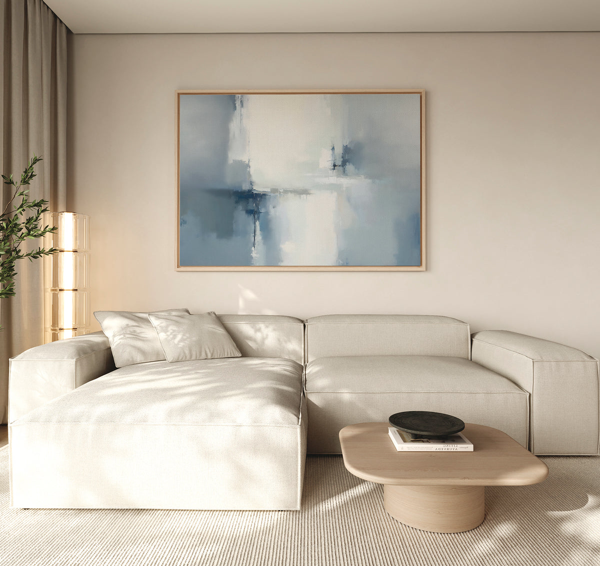A modern living room with a light beige sectional, wooden coffee table, black bowl, tall plant, and the Silver Cross Formation Canvas Art - Horizontal featuring abstract blue and white tones on the wall. Natural light fills the space.