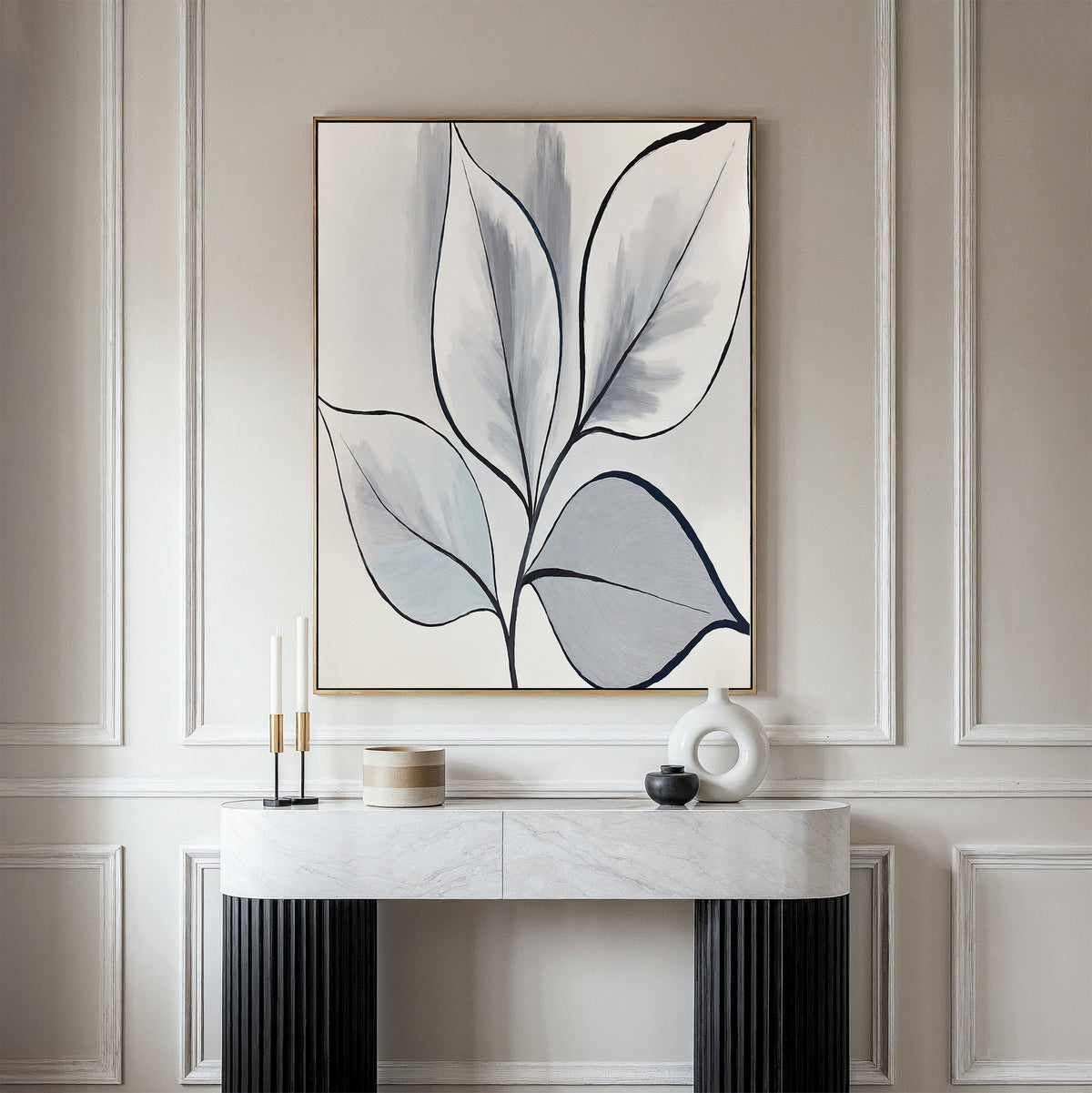 A minimalist modern entryway features a marble-top console table, decorative accents, and the Silver Leaves Canvas Art - Vertical in neutral tones on a light paneled wall for an elegant touch of modern home decor.