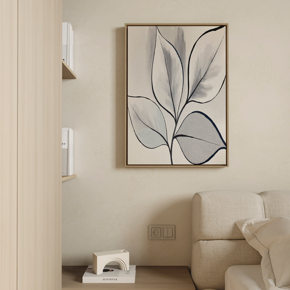 A minimalist living room corner featuring a beige sofa, light wood shelves filled with books, a small abstract sculpture, and the Silver Leaves Canvas Art - Vertical as striking minimalist wall art.