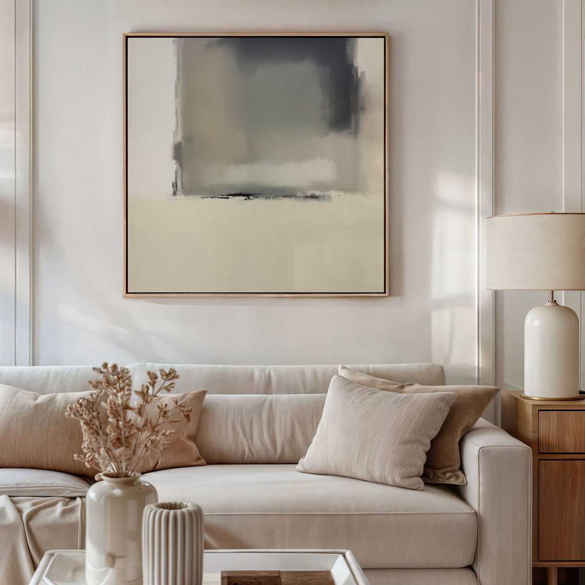A modern living room with a beige sofa, neutral cushions, a table with dried flowers in a vase, a ceramic lamp on a wooden side table, and the Smoke Boundary Canvas Art - Square displayed above.