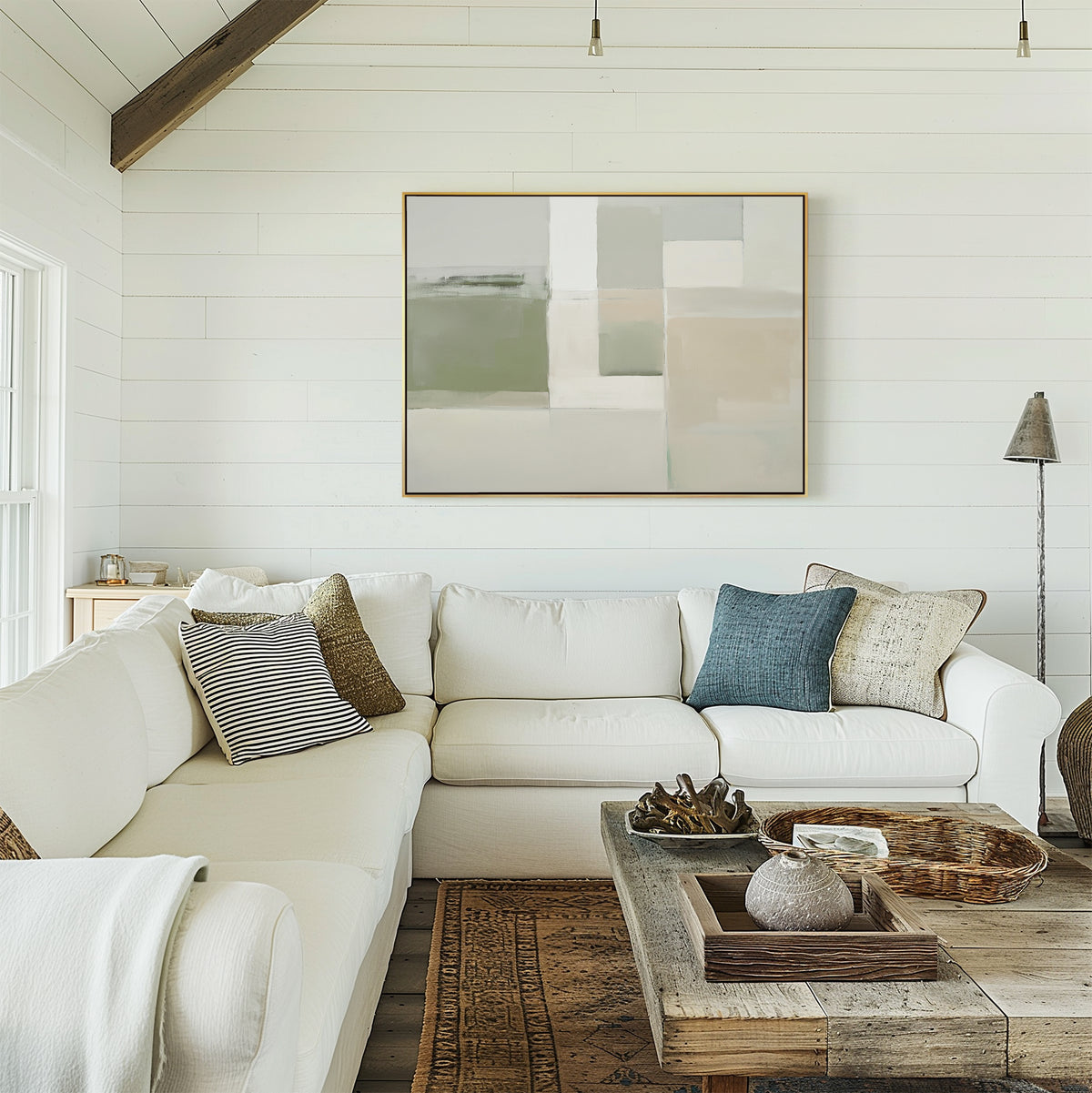 A cozy modern living room features a white sectional sofa, textured pillows, a rustic wood coffee table with decor, a patterned rug, and the Soft Geometric Planes Canvas Art - Horizontal on white shiplap walls. Natural light streams in from the window.