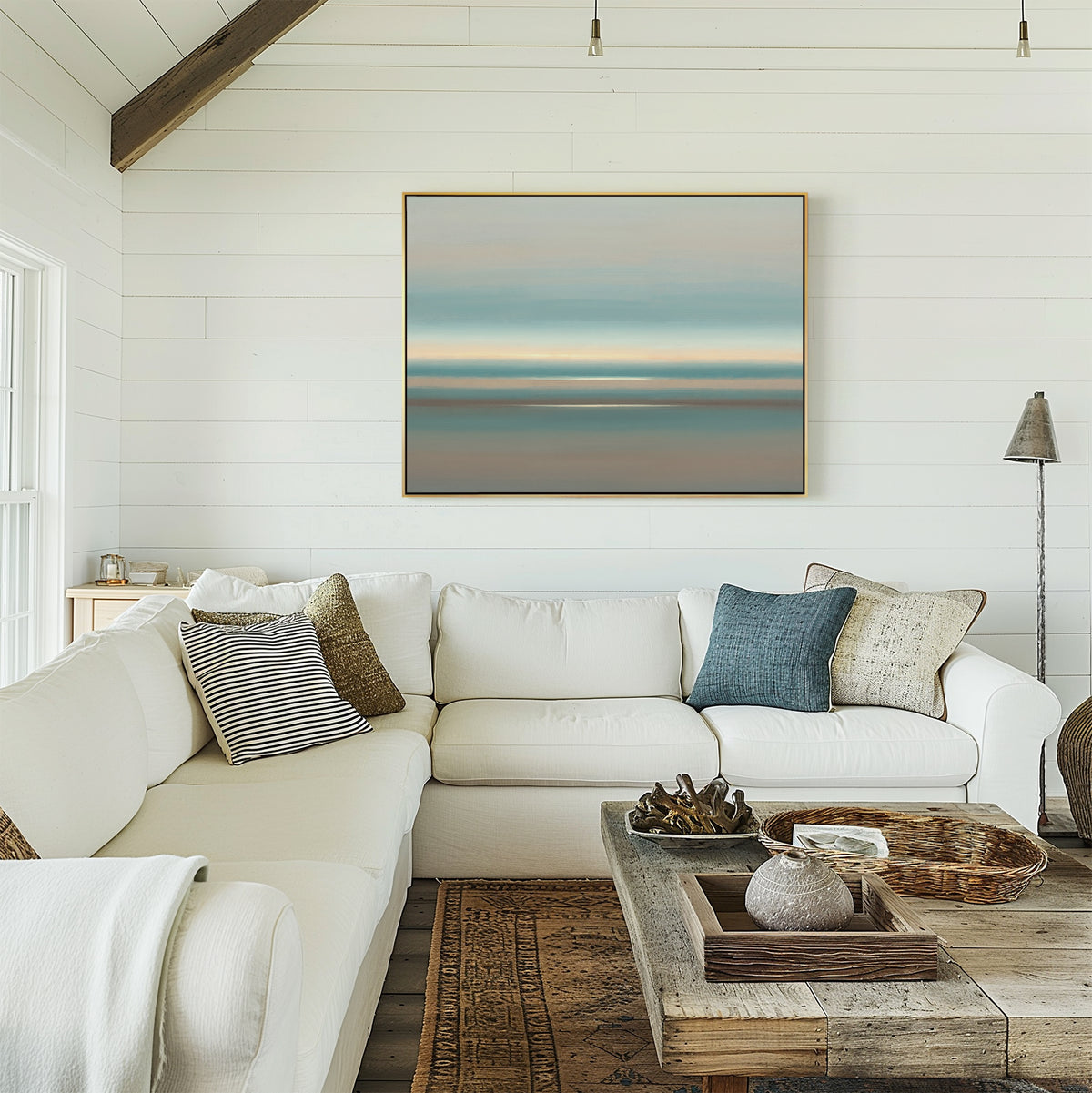 Bright living room with white shiplap walls, a large sectional sofa and assorted pillows, rustic wood coffee table with decor, and the Soft Tide Layers Canvas Art - Horizontal above the couch. Sunlight streams through the window.
