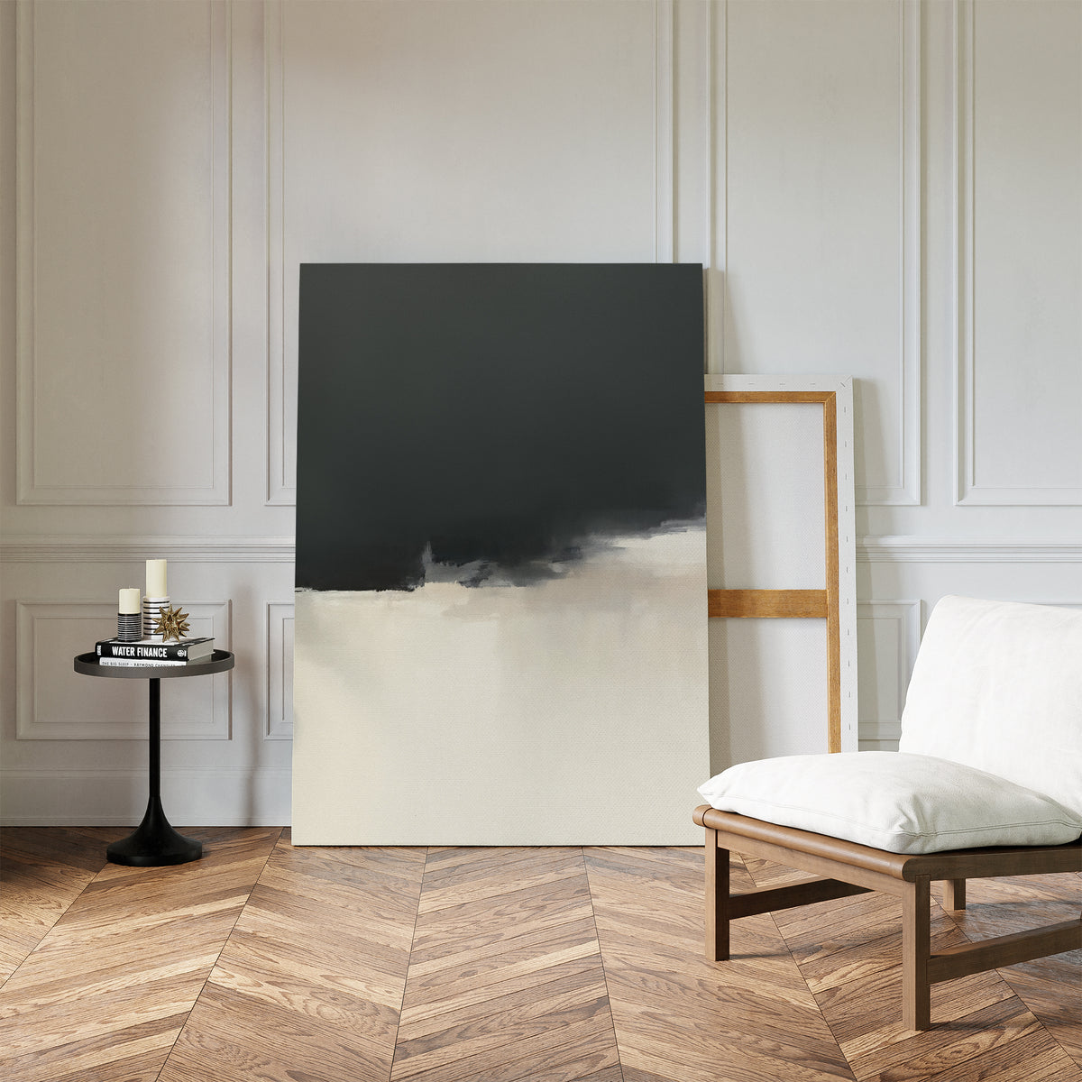 A modern minimalist room with the Tempest Brewing Canvas Art - Vertical leaning against a white paneled wall, a round black side table with candles, and a cushioned wooden chair on a herringbone wood floor.