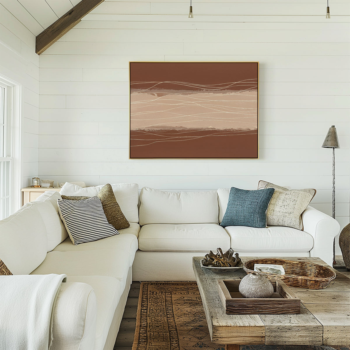 A bright living room with white shiplap walls, a white sectional sofa with assorted pillows, a wooden coffee table, and the Terracotta Currents Canvas Art - Horizontal above the couch. Natural light pours in through the window.