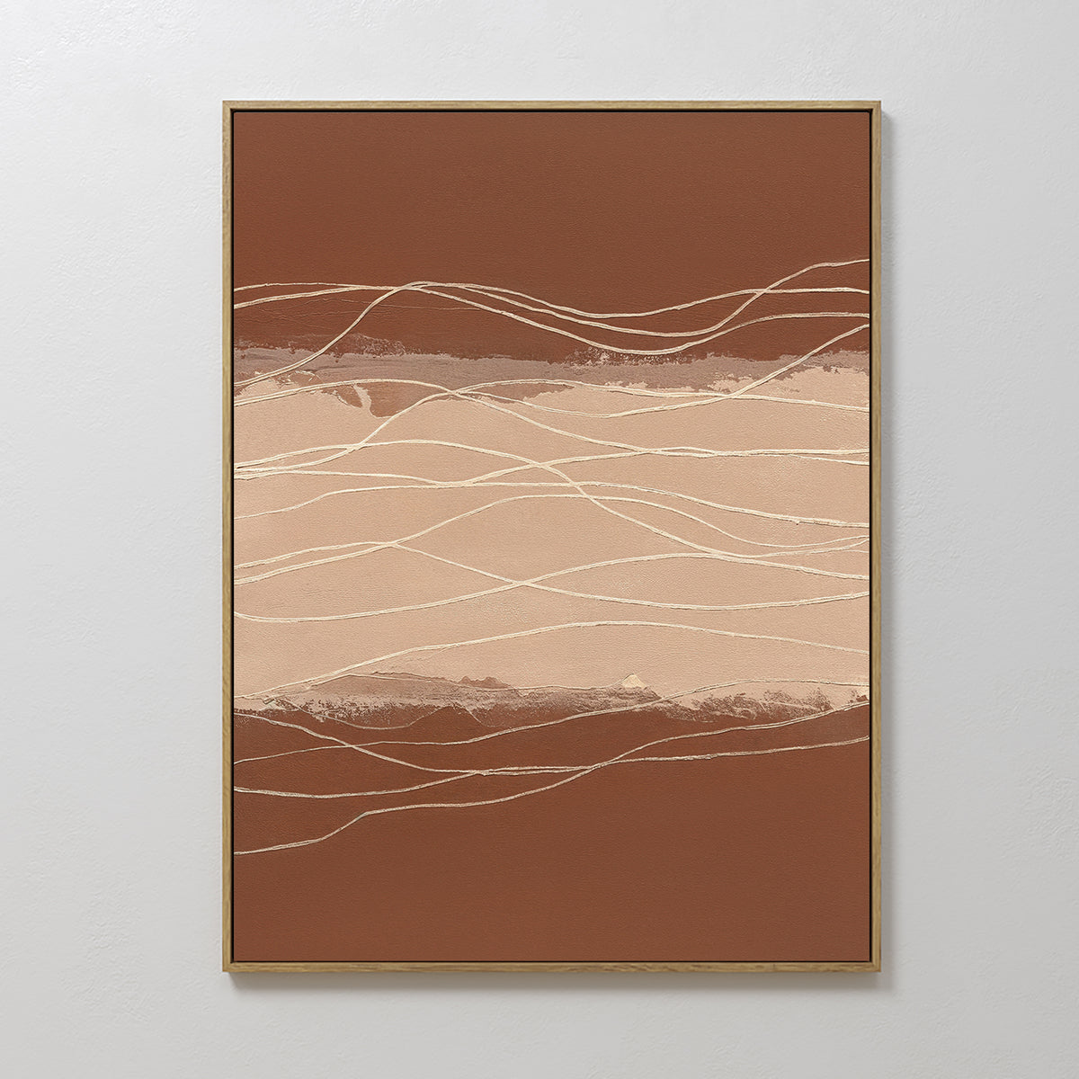 Terracotta Currents Canvas Art - Vertical features abstract wavy lines in beige, cream, and brown, framed in thin gold against a light gray wall. This contemporary print suggests movement—ideal for lovers of terracotta-inspired wall art.
