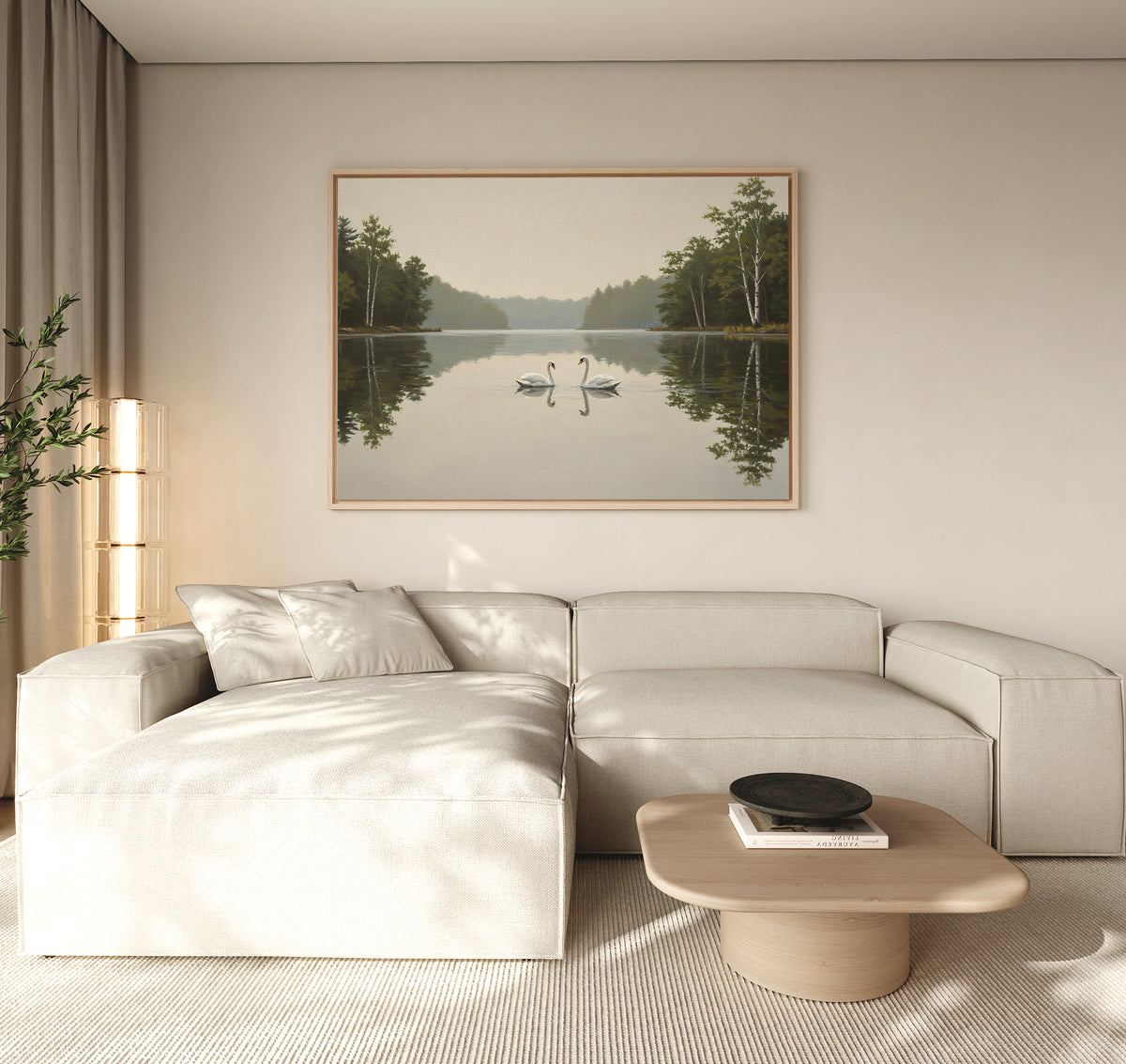 A modern living room with a light beige sectional sofa, a wooden coffee table, and the Twin Swans Serenity Canvas Art - Horizontal: a large framed artwork of two swans on a calm lake with trees, hanging on the wall.