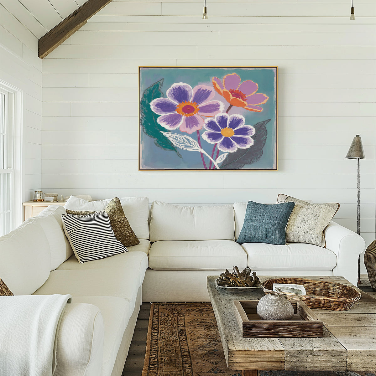 A bright, airy living room with a white sectional sofa, earth-toned pillows, a rustic wooden coffee table, and the Vibrant Petals Canvas Art - Horizontal as striking wall art above the couch.
