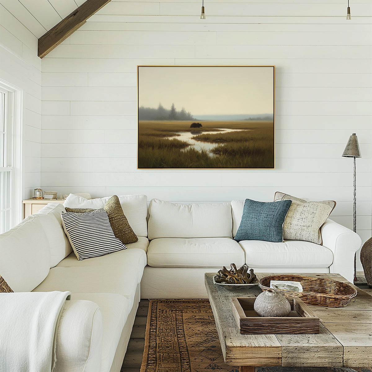 A bright, cozy living room with a white sectional sofa, neutral and blue throw pillows, a rustic wooden coffee table, and the Wetland Bear Canvas Art - Horizontal displayed on the white shiplap wall.