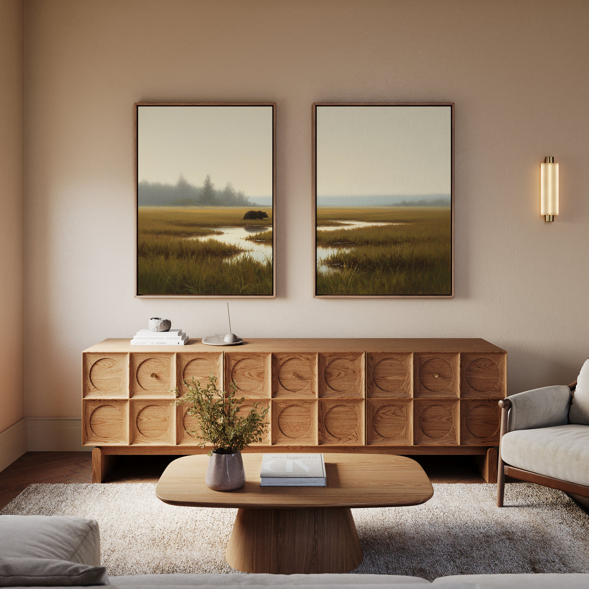 A modern living room with a wooden sideboard, coffee table, vase with greenery, and sofa. The Wetland Bear - Set Of 2 hangs above the sideboard, while a wall sconce provides warm lighting.