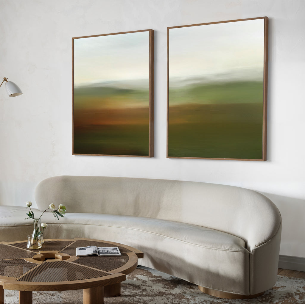 A modern living room features a curved beige sofa, a round wooden coffee table with flowers and a magazine, and the Lush Landscape Set of 2 abstract wall art prints above the sofa for stylish decor.