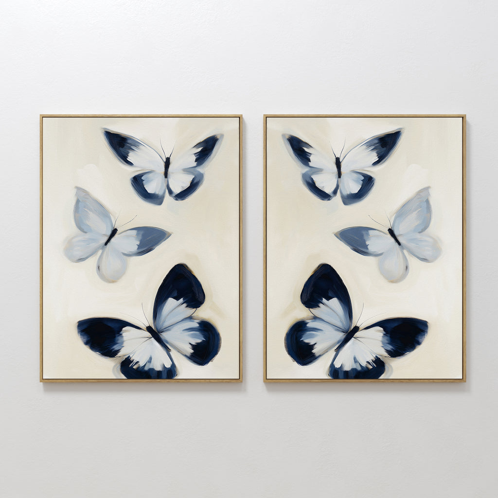 The Midnight Wings Set of 2 features framed wall art with abstract blue and white butterflies on light beige backgrounds, making stylish modern decor to elevate any room.