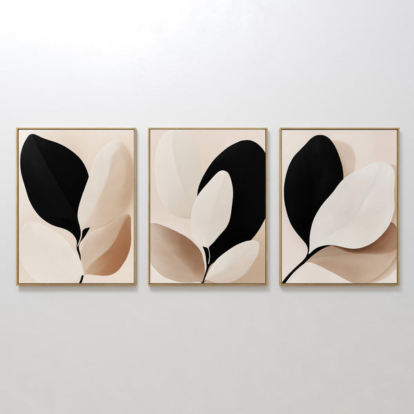 The Monochrome Flora Set of 3 features minimalist framed artworks with abstract leaf designs in black, beige, and cream—ideal for modern living rooms or as striking botanical wall art.