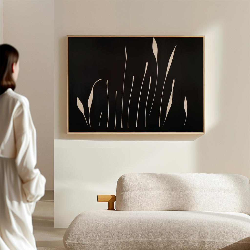 A woman in a white robe stands in a minimalist living room, facing a sofa and the Botanical Silhouettes Abstract Canvas Art featuring beige plant shapes on the wall.