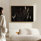 A woman in a white robe stands in a minimalist living room, facing a sofa and the Botanical Silhouettes Abstract Canvas Art featuring beige plant shapes on the wall.