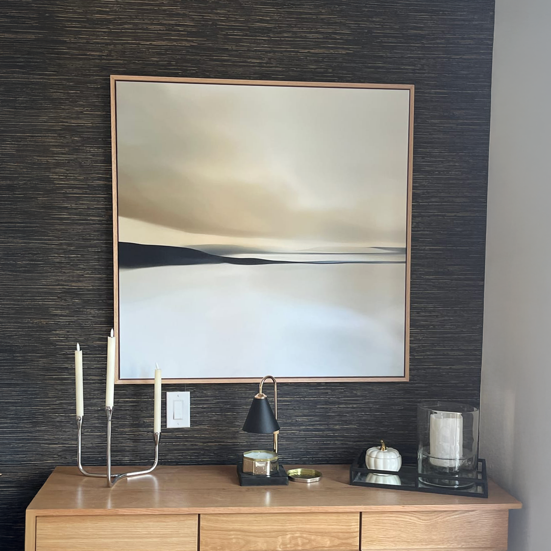 The Desert Quietude Abstract Canvas Art by My Store, featuring soft neutral tones and a thin wood frame, hangs above a minimalist sideboard—an elegant accent to elevate your living room décor.